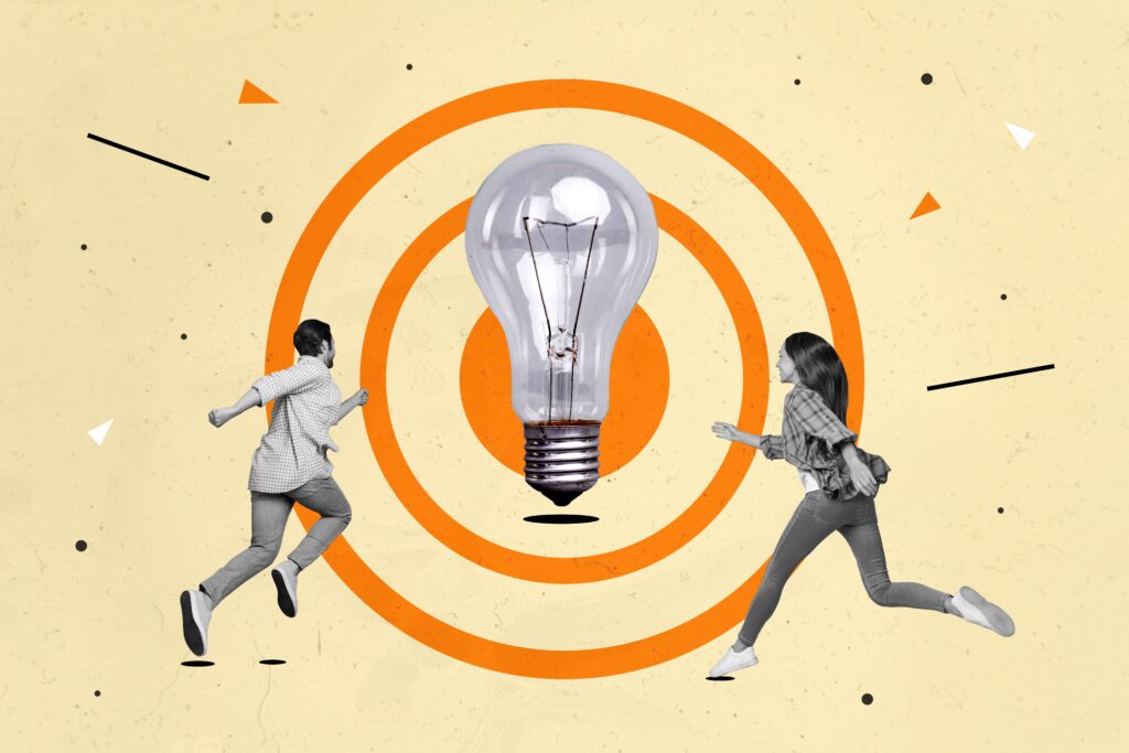 two small people black white colors running towards big light bulb