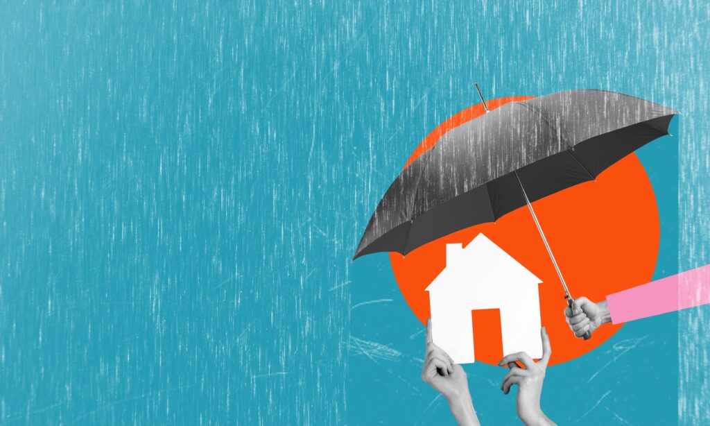 hand holding umbrella over paper house on a blue background