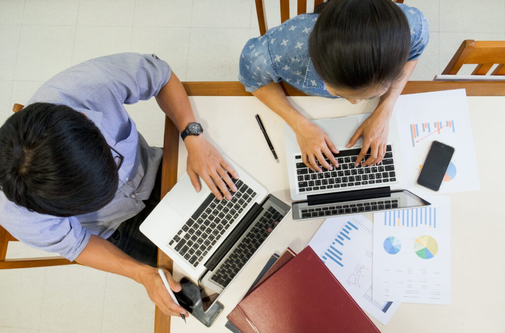 Overhead view of two colleagues working on charts
