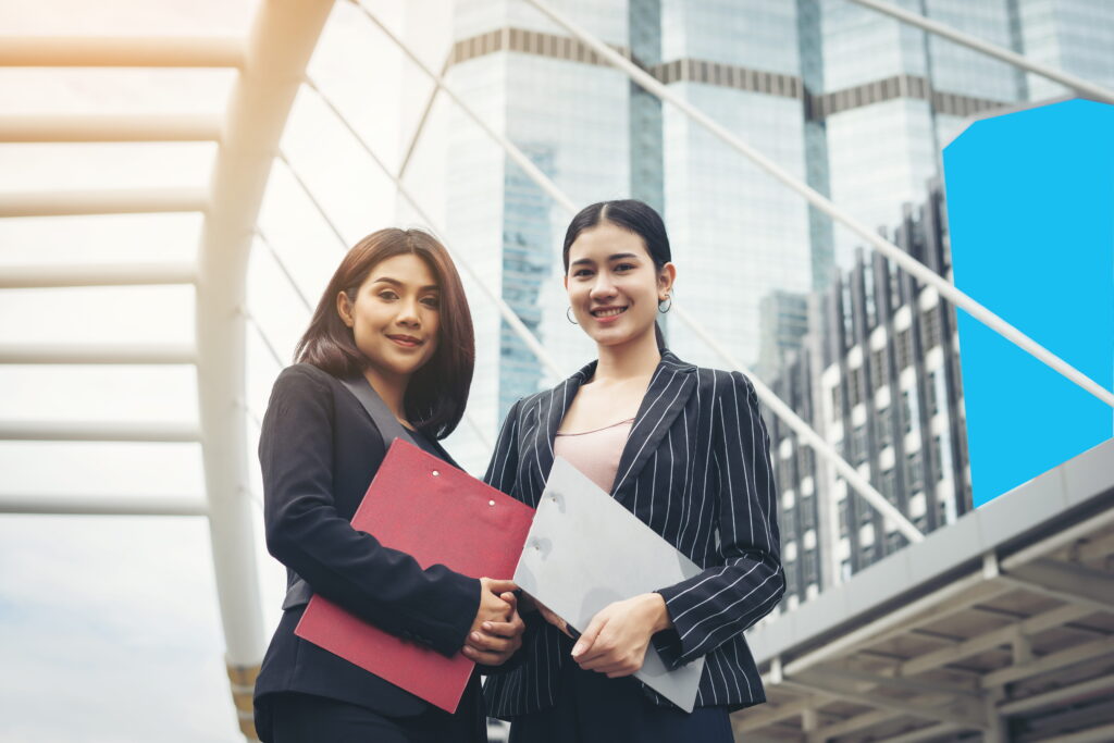 Two business woman standing and discussing in front of the office