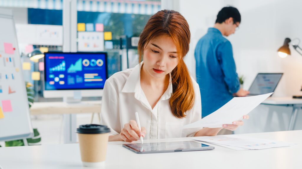 Young businesswoman drawing, writing and using pen with digital tablet computer