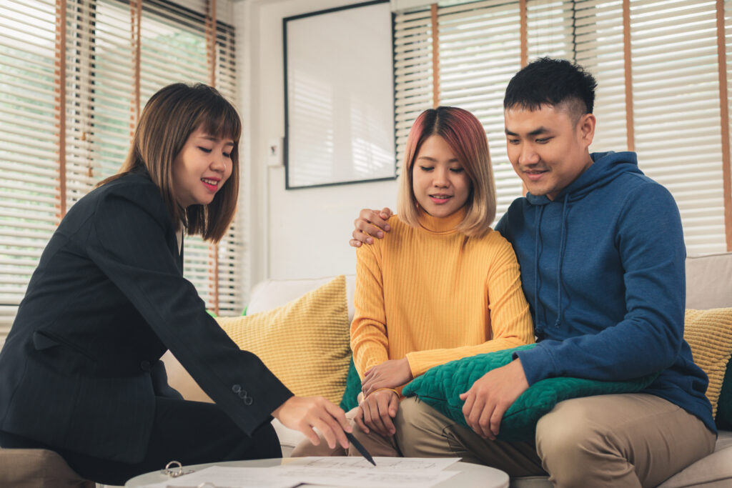 Happy young asian couple and realtor agent