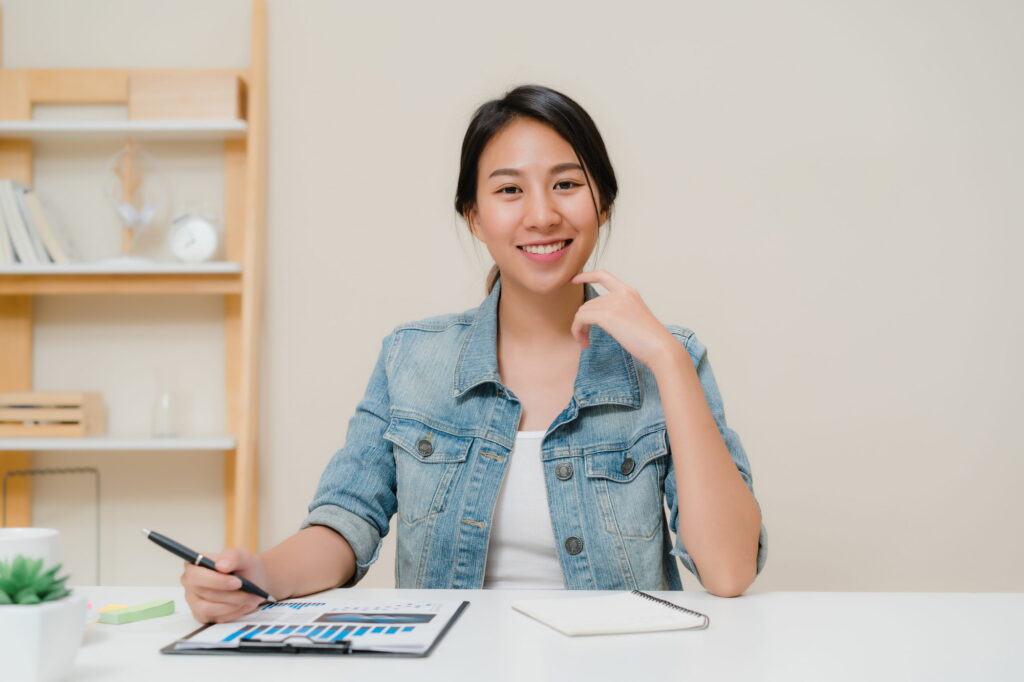 Asia business woman feeling happy smiling and looking to camera while relax at home office